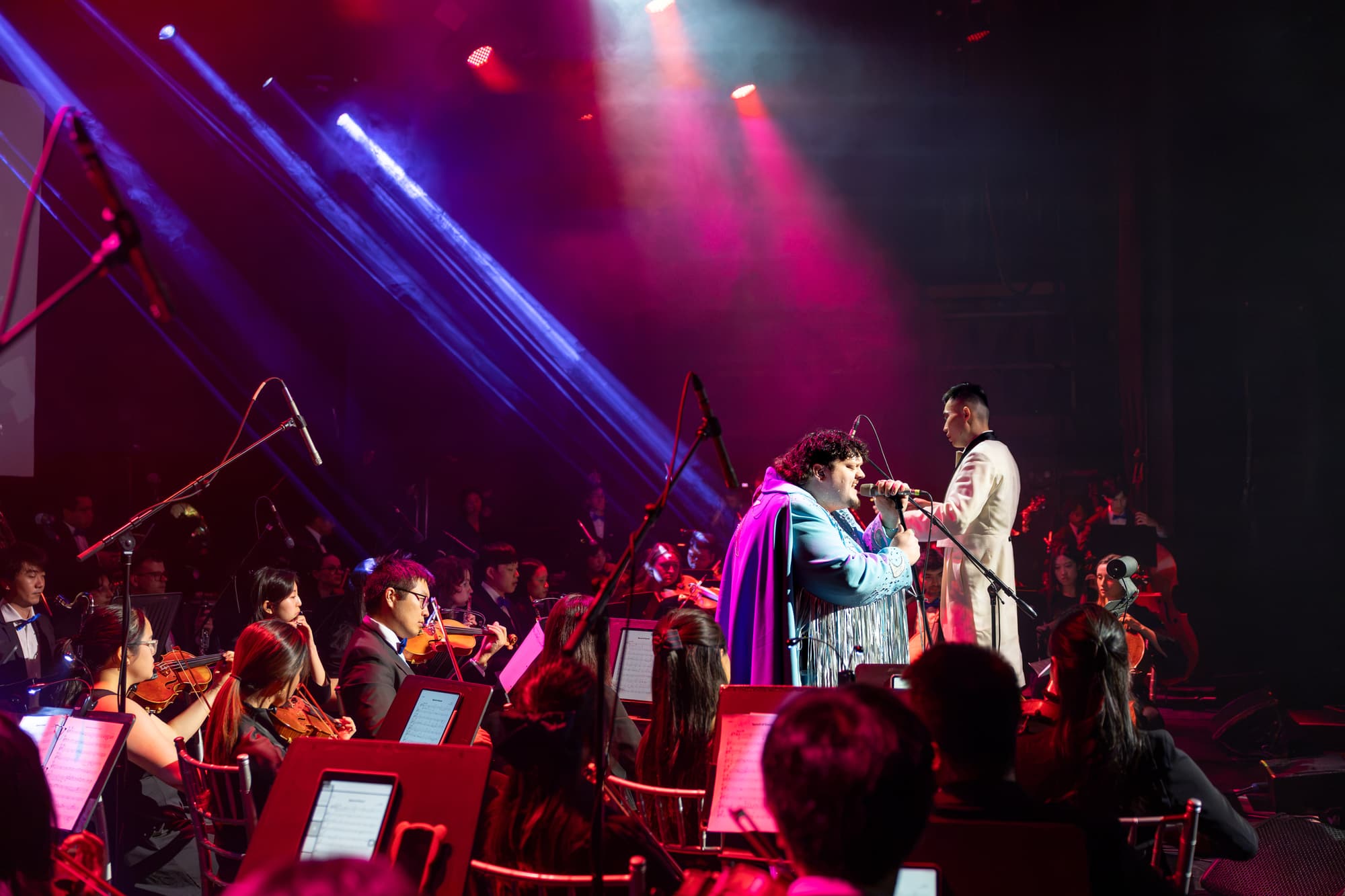 The Toronto Pops Orchestra playing live with Juno Award winning artist TALK under purple and blue stage lights
